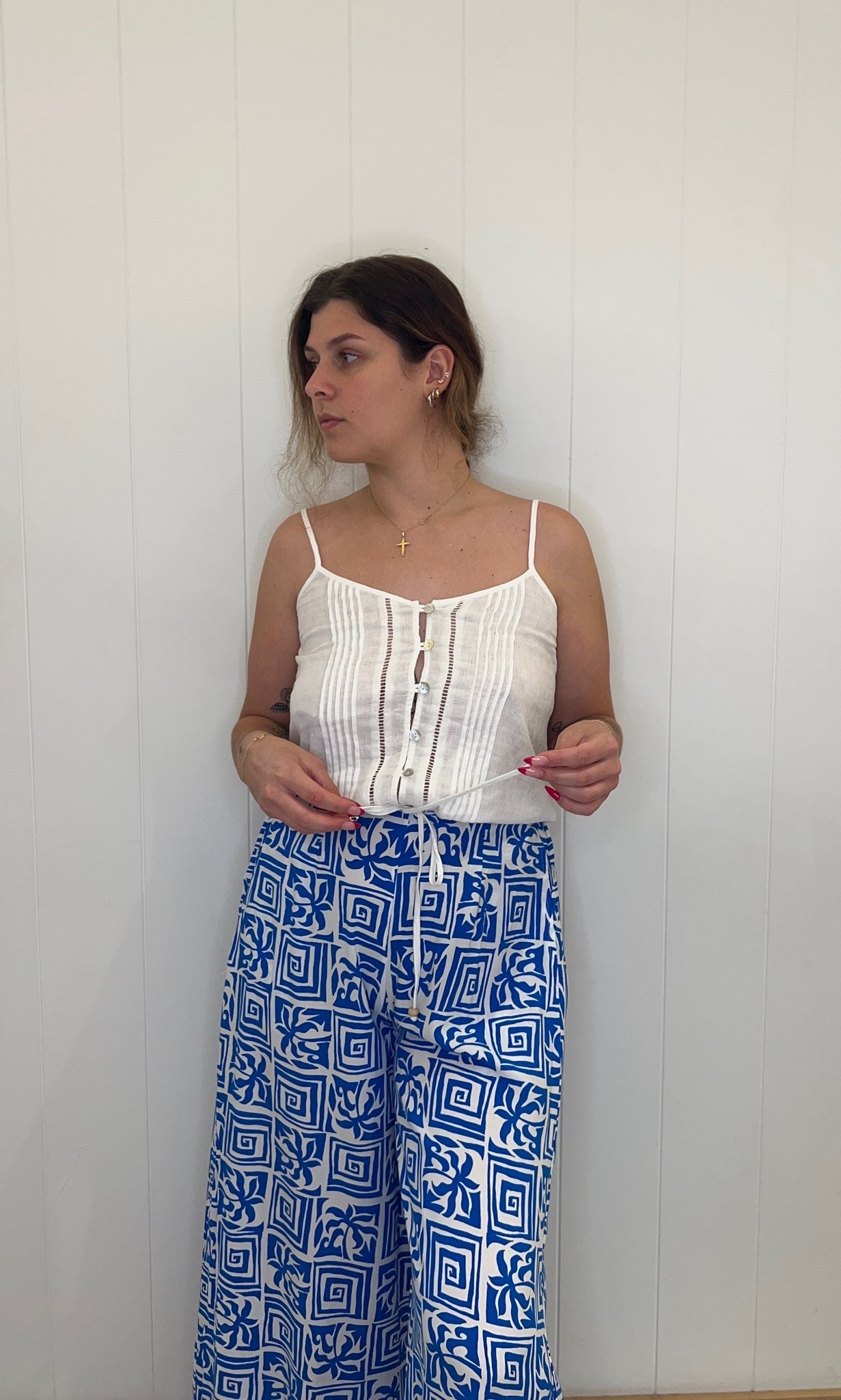 Introduce timeless elegance to your wardrobe with the Bailee Top. Its expertly tailored V-neck and button detailing creates a polished, refined look that pairs just as effortlessly with jeans as it does with a skirt. The drawstring waist emphasises the silhouette, while the adjustable spaghetti straps provide a perfectly customised fit.