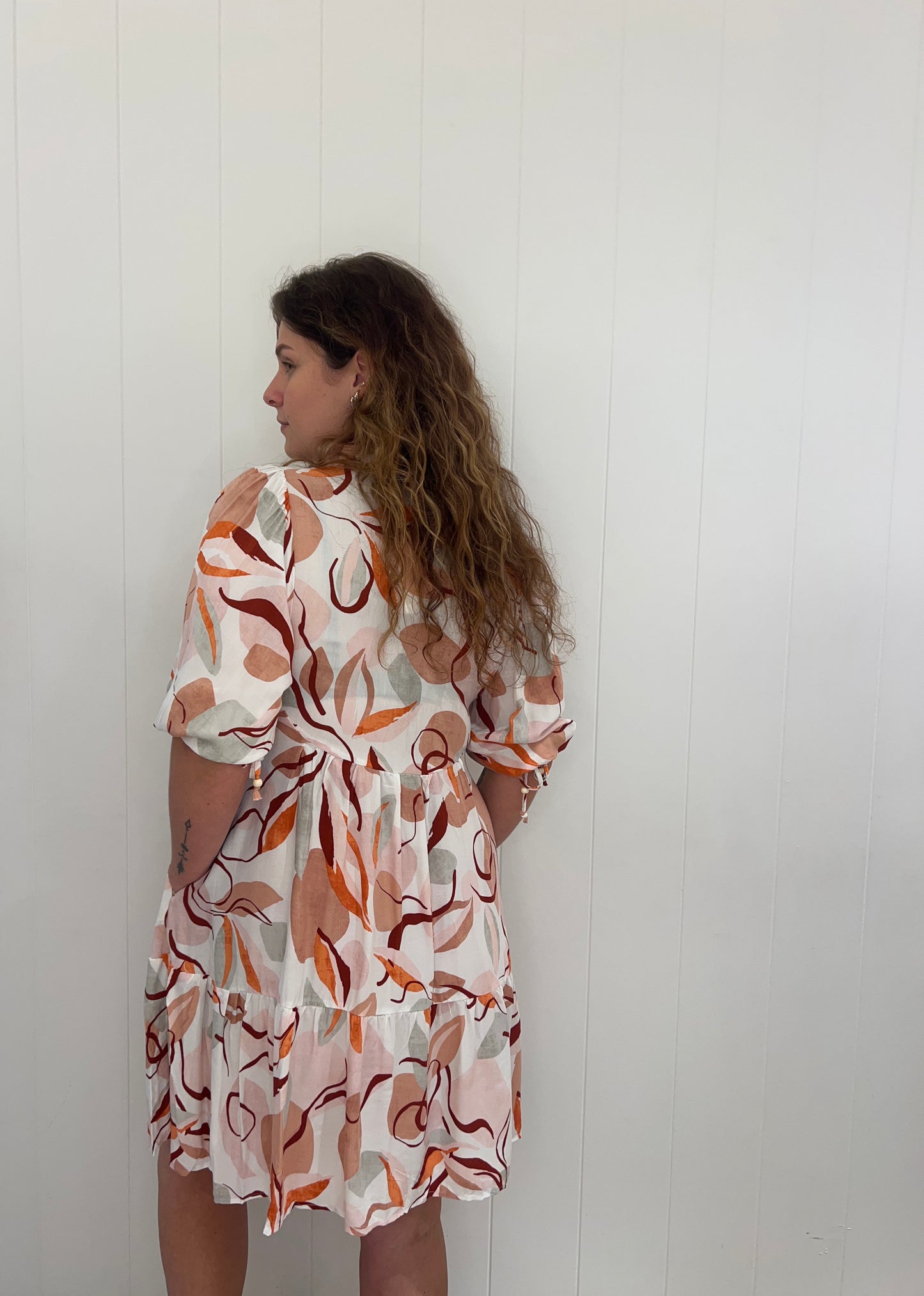 Experience the luxury of the Rosie Mini Dress. Crafted with elegant button details, a V-neckline, elasticated cuffs, and a tiered skirt, this dress provides a stunning and sophisticated look for any occasion.
