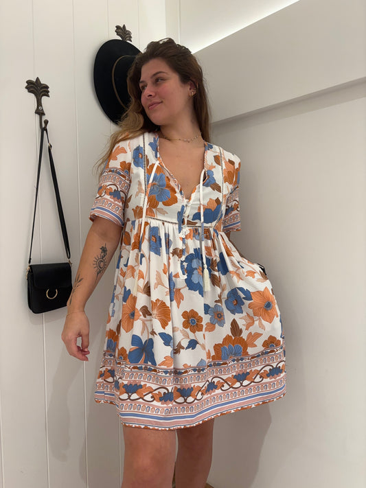 Get ready for autumn with our playful and stylish mini dress. Featuring a V neckline, tie up and tassel details, and button accents, this dress is perfect for any occasion. Plus, with convenient pockets, you'll have everything you need at your fingertips. Say goodbye to boring outfits and hello to the perfect mix of style and functionality!