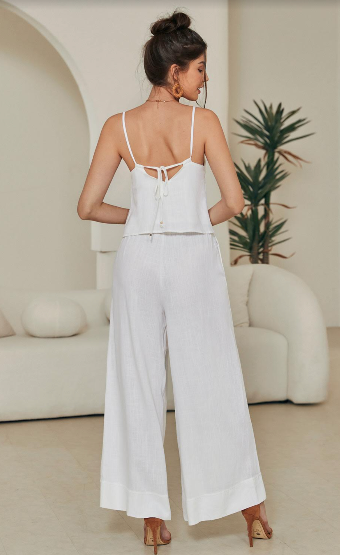 Discover effortless luxury with the Tara Linen Crop Top. Boasting gold-plated details, a tie-up back, a cropped length, and delicate spaghetti straps, this sophisticated piece is both timeless and eye-catching. The lined design ensures a comfortable fit, perfect for any special occasion.