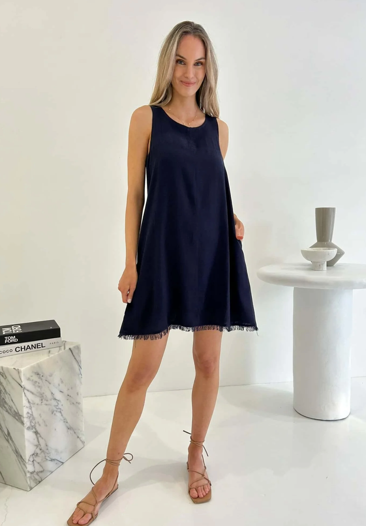 Experience effortless style in our Freya Dress, crafted in luxurious navy fabric. The frayed hem and shift fit add a touch of sophistication, while the functional pockets and lining provide practicality. Elevate your wardrobe with this elegant and exclusive piece.