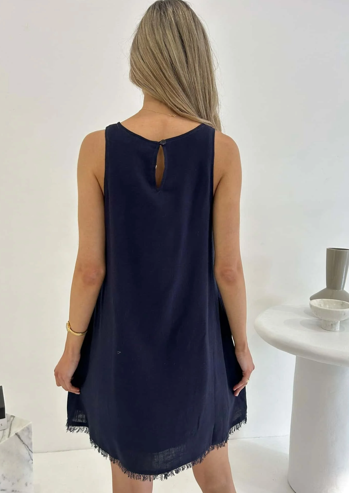 Experience effortless style in our Freya Dress, crafted in luxurious navy fabric. The frayed hem and shift fit add a touch of sophistication, while the functional pockets and lining provide practicality. Elevate your wardrobe with this elegant and exclusive piece.