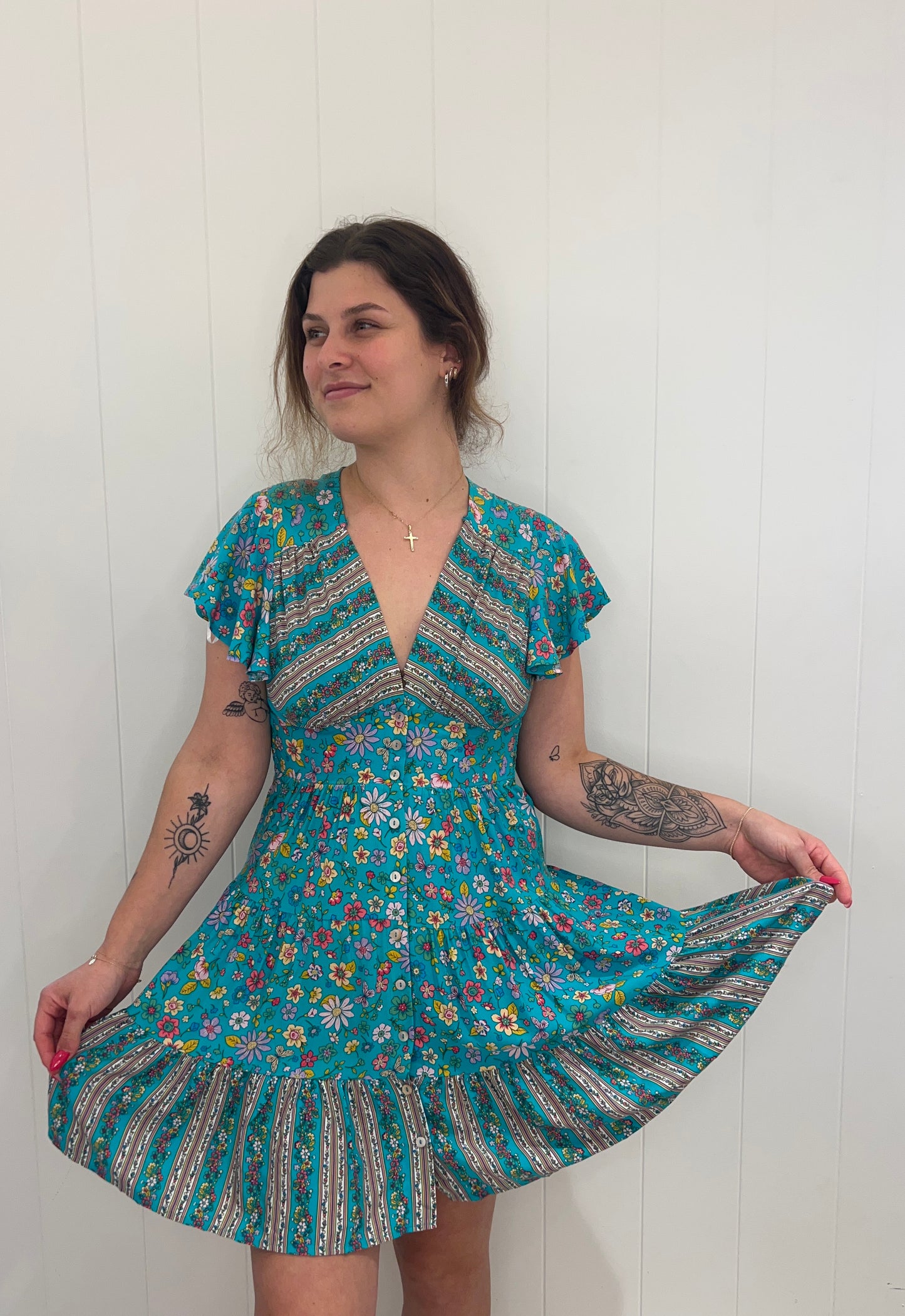 Introducing the Xoey Mini Dress, a flawless piece of sophistication and elegance. Crafted from soft fabric, the dress is designed with a v-neckline, delicate button detail, and an elasticated waist for subtle definition, while the tiered style and sweeping bell sleeves lend a romantic touch. Perfect for any special occasion.