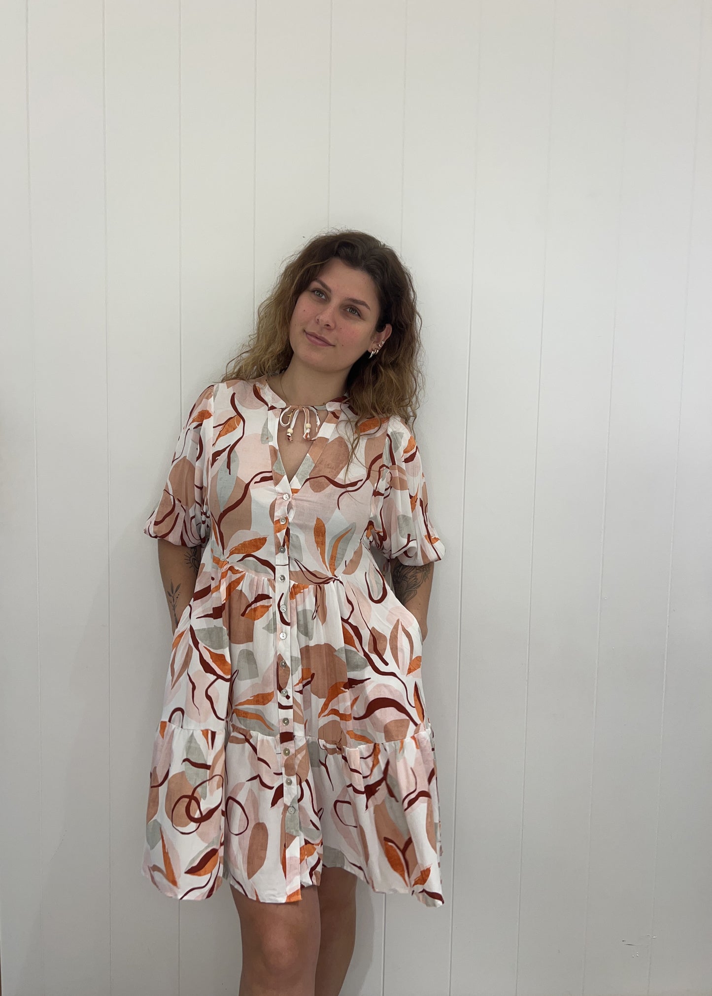 Experience the luxury of the Rosie Mini Dress. Crafted with elegant button details, a V-neckline, elasticated cuffs, and a tiered skirt, this dress provides a stunning and sophisticated look for any occasion.