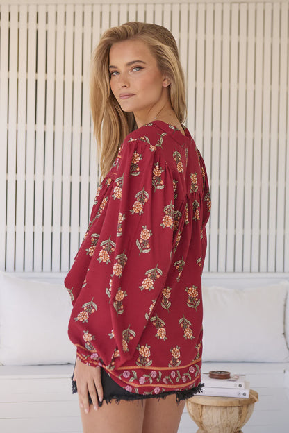 Take your style to the next level with our Bee Blouse - Grenache Print! Featuring a playful V neck line and a small collar, this blouse is perfect for any occasion. The long sleeves with relaxed cuffs and relaxed style add a touch of effortless chic. Buzz-worthy fashion at its best!