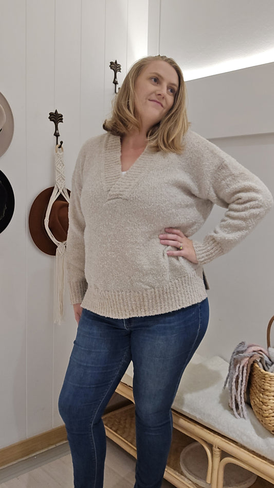 Introducing the Alvi Jumper - Cream! Keep warm in style with its cozy design. The V-neck adds a touch of elegance, while the cuffed sleeves provide a snug fit. Perfect for a chilly day (or night) out!