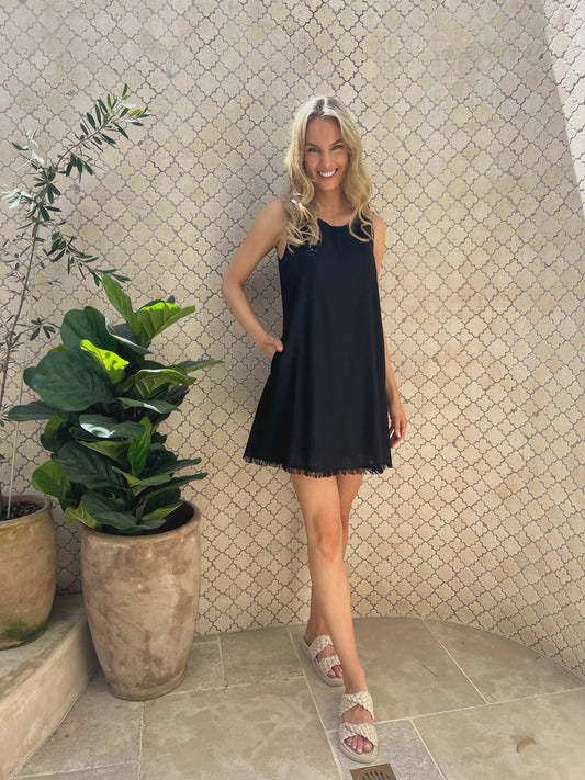 Indulge in effortless elegance with the Freya Dress in stunning black. The frayed hem and shift fit offer a chic silhouette, while the convenient pockets and lined design add both functionality and sophistication. Elevate your wardrobe with this timeless piece.