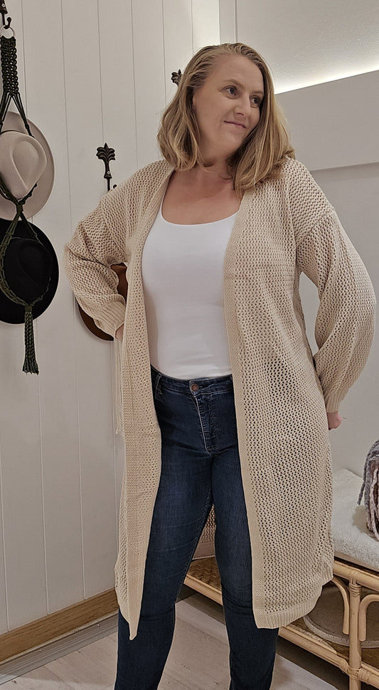 Cozy up in the Kelly Knit Cardi. This long cardigan features cuffed sleeves and an open knit weave for a stylish and comfortable look. Perfect for layering over any outfit, this cardi is a must-have for your wardrobe.