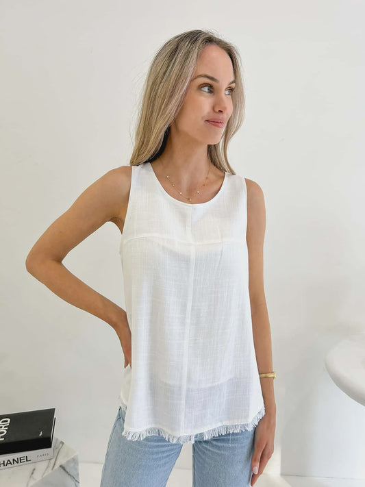 Indulge in the elegant and exclusive world of fashion with the Freya Top in White. Crafted from a luxurious blend of linen and cotton, this lined top features a frayed hemline and scoop neckline, adding a touch of sophistication to your wardrobe. Elevate your style with this tasteful and versatile piece.