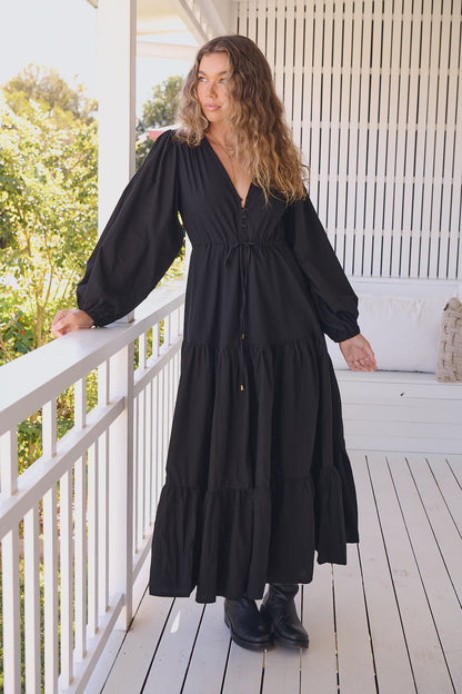 Unleash your inner goddess in the Teresa Maxi dress! With a sleek v-neckline and billowy sleeves, this dress is both elegant and comfortable. The button down bust adds a touch of whimsy, while the tie-up waist cinches your waist for a flattering silhouette. Available in versatile Onyx, this dress is perfect for any occasion.(Goddess-worthy!)