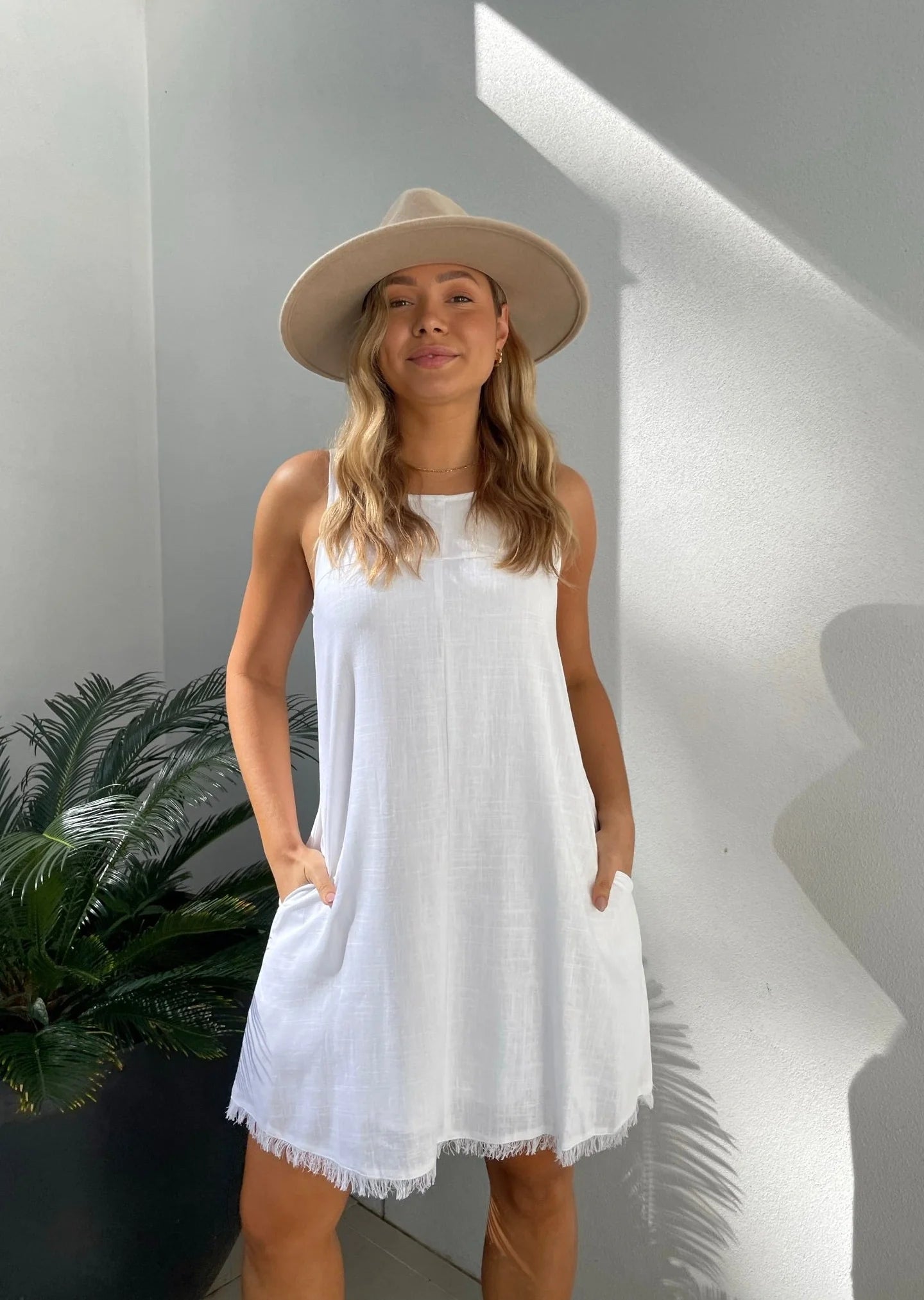 Add style and function to your wardrobe with the Freya Dress! This white dress features a frayed hem and shift fit, keeping you on trend. Plus, with convenient pockets and a comfortable lined interior, you'll never want to take it off. It's a must-have for any fashion-forward and practical individual!