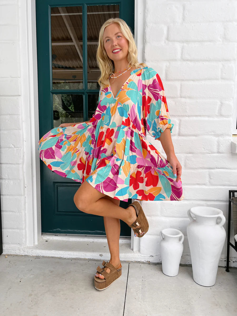This striking Petal Mini Dress boasts an Ohana Print and a playful V Neckline. The tiered style and elasticated cuff sleeves add a touch of whimsy to this must-have piece. Perfect for a fun and carefree day out, this dress will have you feeling like the life of the party!