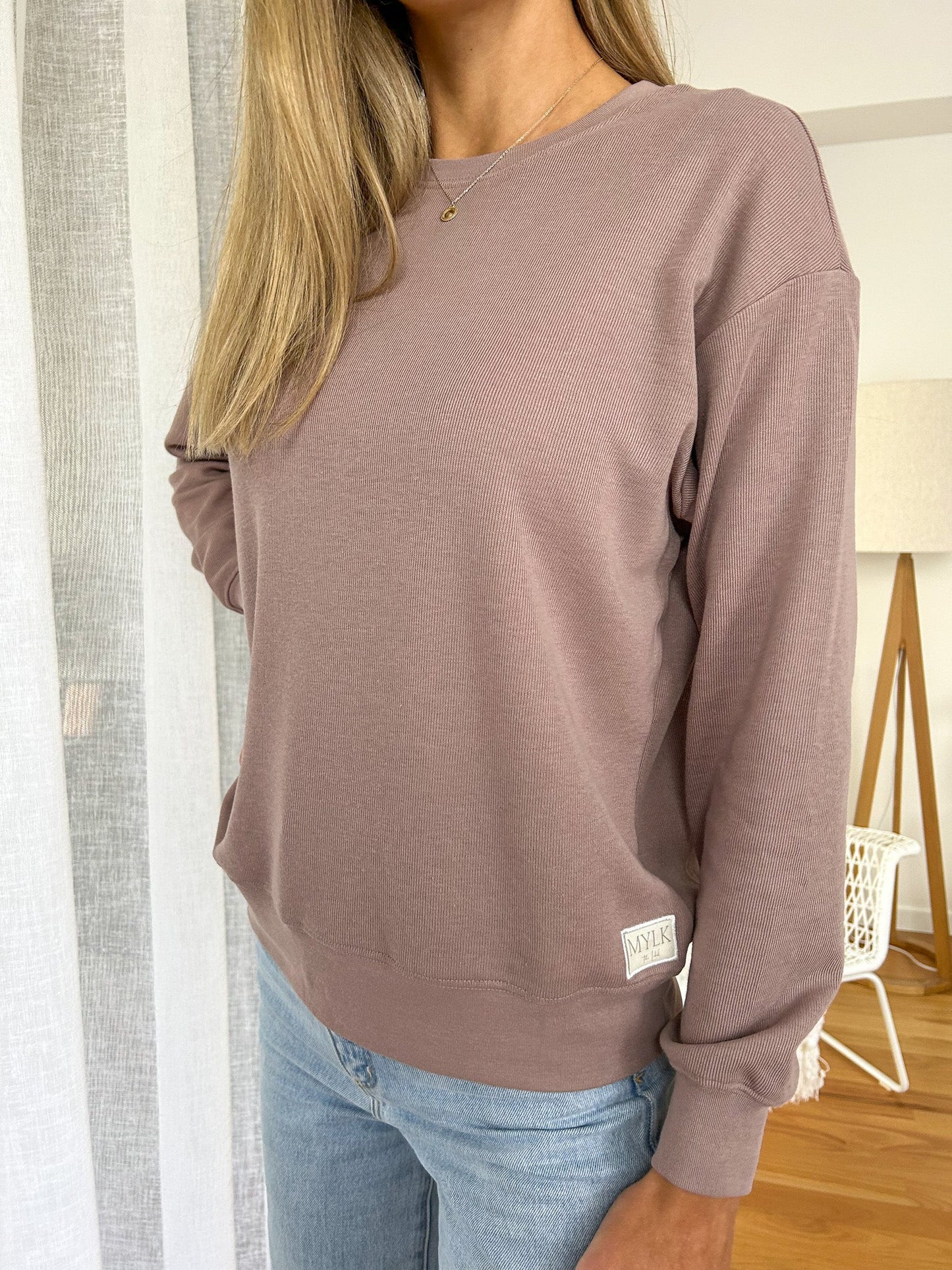 Cozy up in style with the Mylk Lounge Sweater! This long-sleeved, loose-fitting sweater features the signature Mylk logo, adding a touch of personality to your wardrobe. Perfect for lounging or running errands, this sweater will keep you comfortable and effortlessly cool.