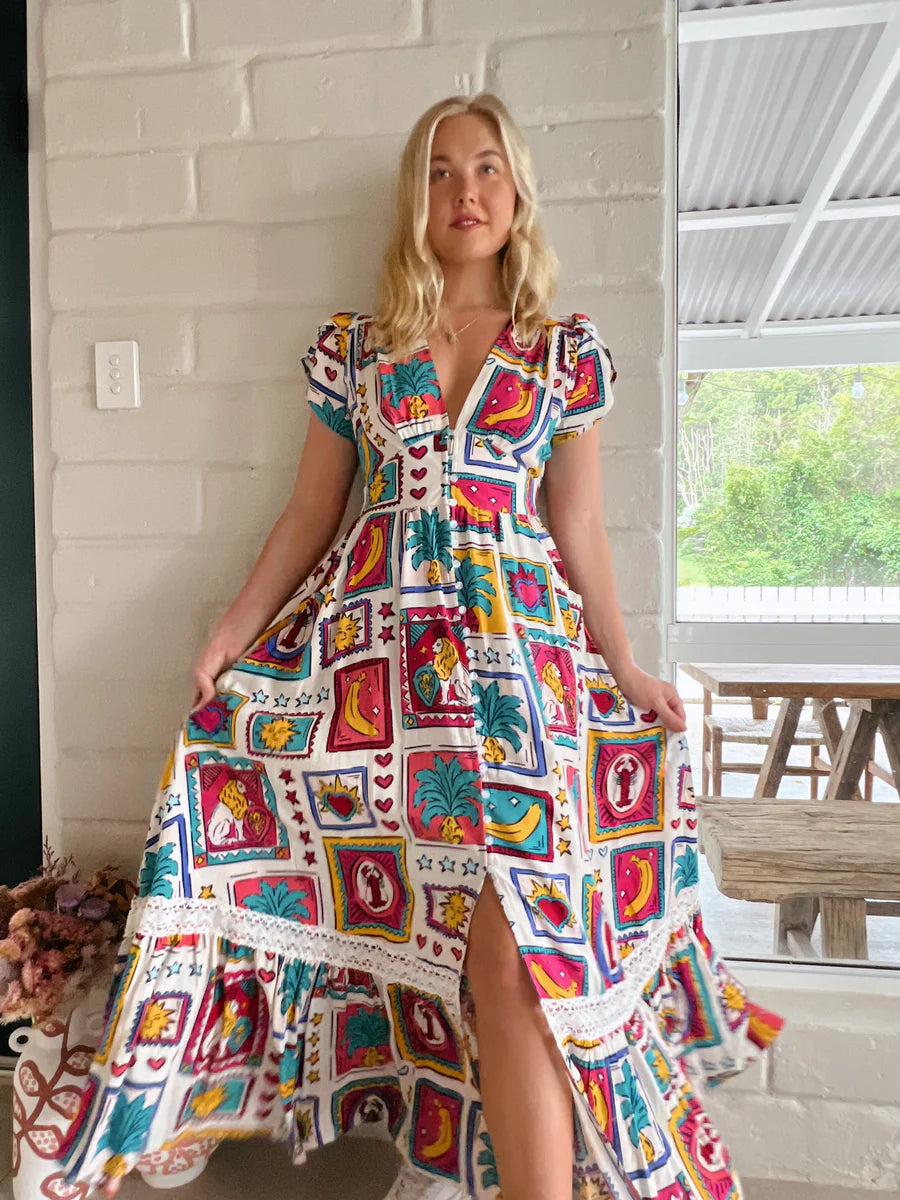 Be the belle of the ball in the playful and quirky Tabitha Maxi Dress - Alice Print! This stunning dress features cap sleeves, buttoned details from waist to knee, and pockets for convenience. With a flattering V-neckline and elastic insert on the back, this dress is both stylish and comfortable. Complete with delicate lace detailing and a subtle frill hemline, this dress is perfect for any occasion.