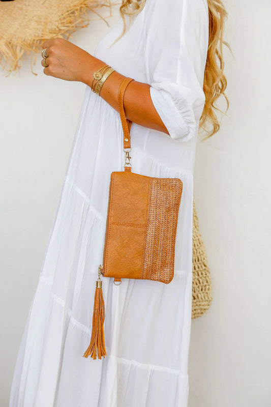 Make a statement with our 2 Tone Woven Clutch in Tan! This playful piece features a unique half woven, half faux leather design that adds a touch of quirk to any outfit. Plus, the lined inside and included long and wrist straps make it both fashionable and functional. Don't forget the matching tassel zipper for a stylish finishing touch!