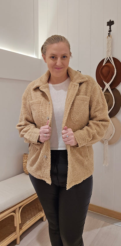 Stay warm and stylish with the Teddi Coat in classic brown! Made with a wool-like material, this coat features 4 practical pockets and button sleeves for added convenience. Perfect for braving chilly weather in style.