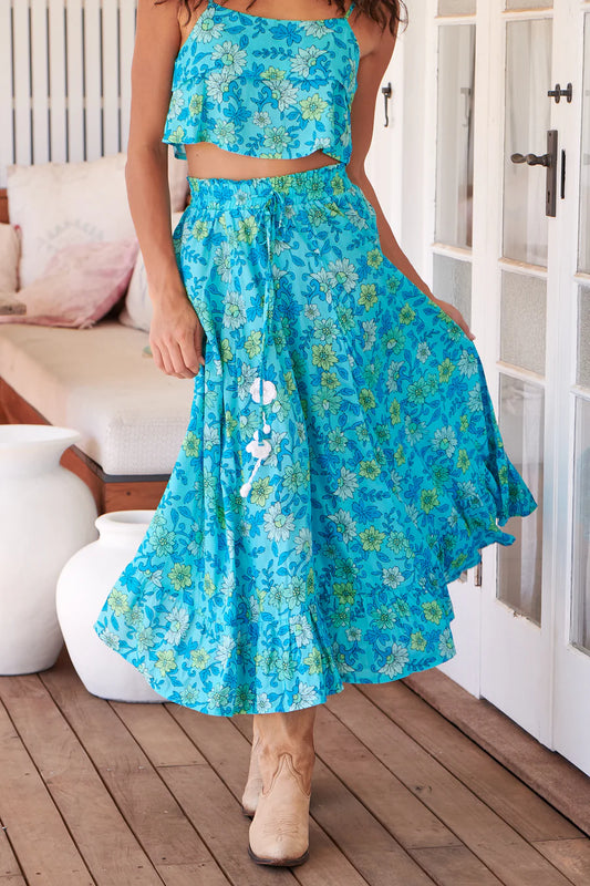 Indulge in the ethereal allure of the Vela Skirt in Sea Crystals Print. The elastic waist and double frilled hemline provide ultimate comfort and flirty movement, while the drawstring waist and pom pom flower trim add a touch of whimsy. Made with a full skirt, this piece is perfect for effortlessly chic looks. Pairs beautifully with the Jordyn Top in Sea Crystals.