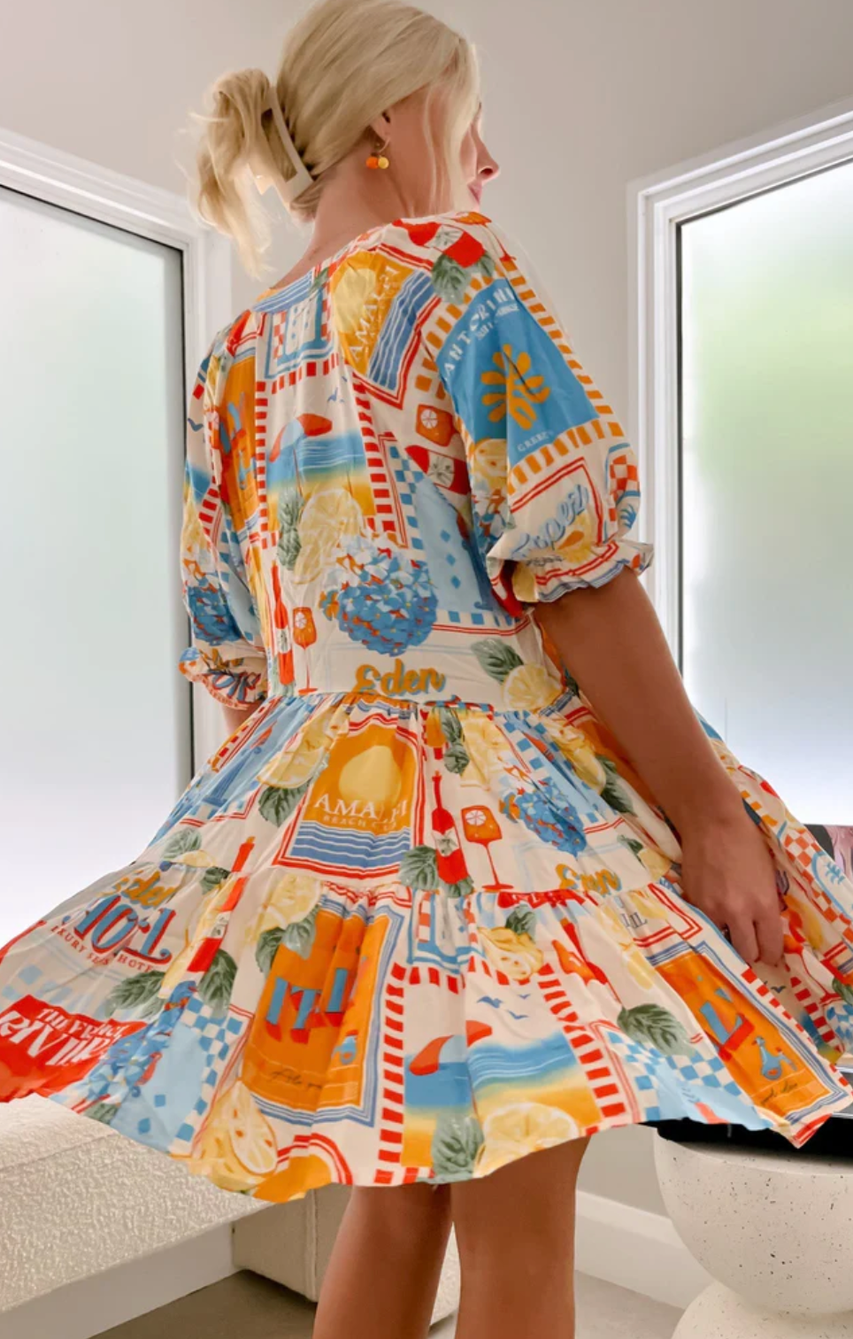 Introducing the Petal Mini Dress in the vibrant Sun Lounger Print! This dress features a flattering V neckline, a tiered smock style for a flowy fit, and 1/2 balloon sleeves with elasticated cuffs and frill detail. Embrace your playful and feminine side with this must-have dress!