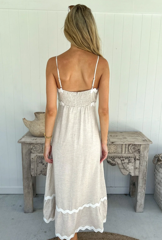 Unleash your playful side in the Lucille Dress. This maxi length dress features an elasticated back and invisible zip for the perfect fit, while adjustable straps add versatility. The natural linen fabric is accented with stylish white ric rac trim for a fun and flirty look.