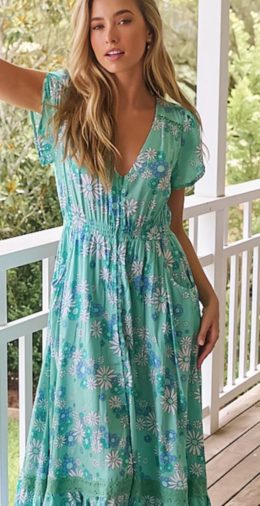 Stay cool (literally, it has short sleeves) and stylish with the Carmen Maxi dress! With a V-neckline, elasticated waist, and full-length button detailing, this dress also has pockets - perfect for holding essentials while on-the-go. The Malina print adds a unique touch to this versatile piece.