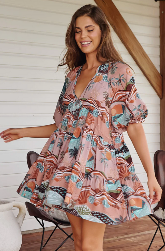 <p>Introducing the playful Petal Mini Dress - Lakeside Serenity. With a V neckline and mandarin collar, this dress exudes charm. The tiered smock style and border hem detail create a flattering silhouette, while the 1/2 balloon sleeves and elasticated cuffs with frill detail add a touch of whimsy.</p> <p>&nbsp;</p>