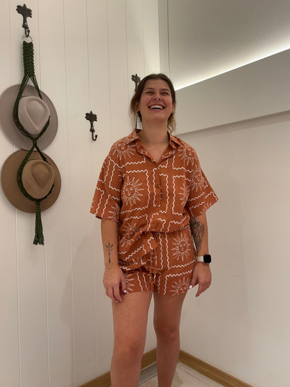Gear up for some sun in our Rust/White Sun Border Set! These shorts feature an elasticated waist for your comfort, along with a chic tie-up design and a flattering lining. The collar and button detail add a touch of sophistication to this playful and practical set.