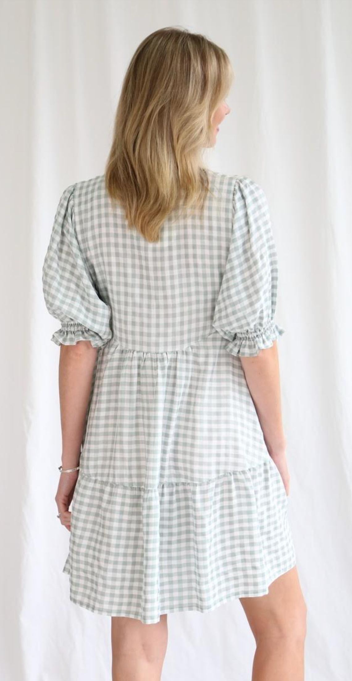 Effortlessly chic and charming, the Ingrid Gingham Mini Dress features a playful v neckline, delightful button details, and a flattering tiered style. With elastic cuff sleeves, this dress offers both comfort and style. Perfect for any occasion, dress it up or down for a versatile and quirky look!