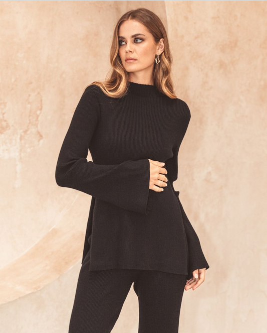 This fitted knit top in classic black features a high neck and long sleeves, making it a versatile and stylish addition to your wardrobe. Perfect for both casual and more dressy occasions, the Carrie Knit Top offers a sleek and comfortable fit that will effortlessly elevate any outfit.
