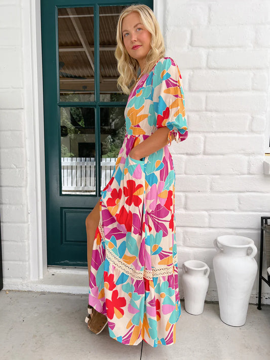 Get ready to wow with the Molli Maxi Dress in the playful Ohana Print! This dress features button detailing, pockets for convenience, and an elasticized waist for a flattering fit. With 3/4 sleeves, it's perfect for any occasion. A must-have for any fashion-forward and fun-loving wardrobe!