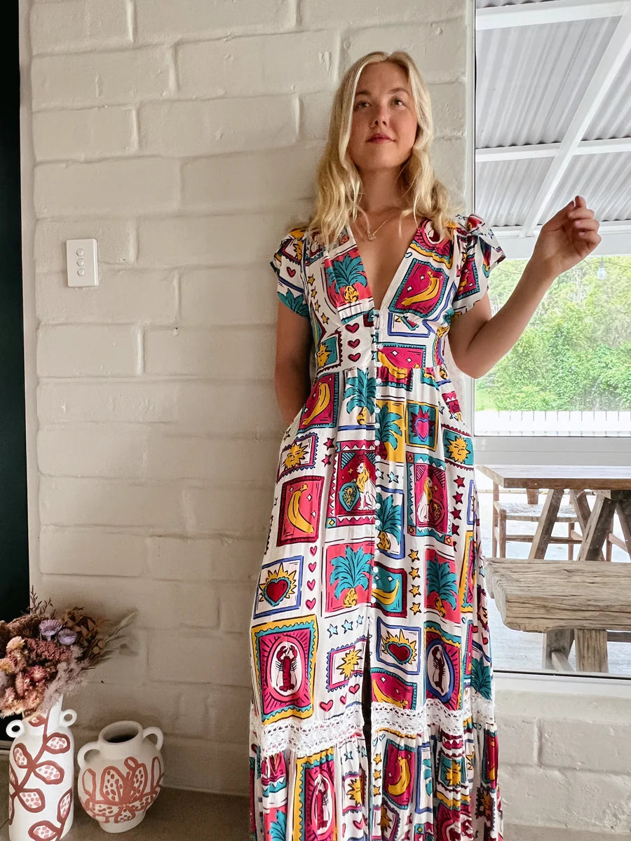 Be the belle of the ball in the playful and quirky Tabitha Maxi Dress - Alice Print! This stunning dress features cap sleeves, buttoned details from waist to knee, and pockets for convenience. With a flattering V-neckline and elastic insert on the back, this dress is both stylish and comfortable. Complete with delicate lace detailing and a subtle frill hemline, this dress is perfect for any occasion.