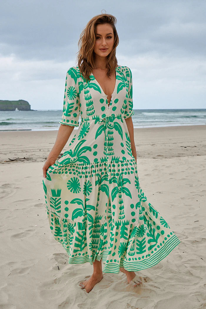 The Tessa Maxi - Nazare Print dress boasts a flattering V neckline and relaxed fit, making it comfy for all-day wear. The drawstring waist cinches in for a customizable fit, while the front split and button bodice add a touch of elegance. With 3/4 sleeves and an elasticated cuff, this dress is both stylish and practical.