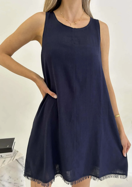 Experience effortless style in our Freya Dress, crafted in luxurious navy fabric. The frayed hem and shift fit add a touch of sophistication, while the functional pockets and lining provide practicality. Elevate your wardrobe with this elegant and exclusive piece.