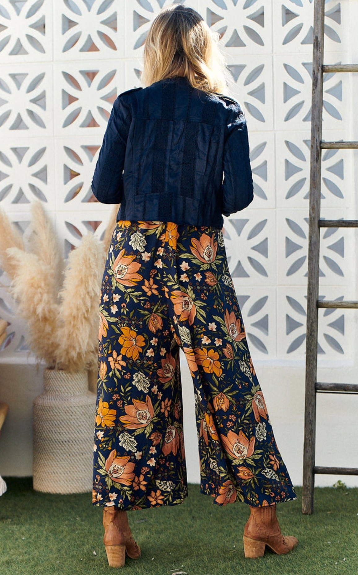 Elevate your style with the Florida Jumpsuit in Navy California Poppy. Featuring elegant pleated details and delicate shoestring straps, this jumpsuit exudes sophistication. Designed with a cropped ankle length and wide leg pants, it's perfect for any occasion. Indulge in luxury with this exclusive piece.