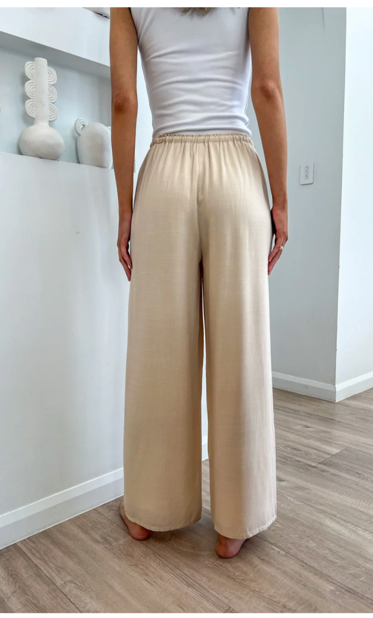 These cream-colored linen pants are perfect for a day out with pockets for all your essentials. Stay comfortable with a drawstring and elasticated waist, and stay stylish with a lightweight lining. A versatile addition to your wardrobe, these pants bring both fashion and function to your outfit.