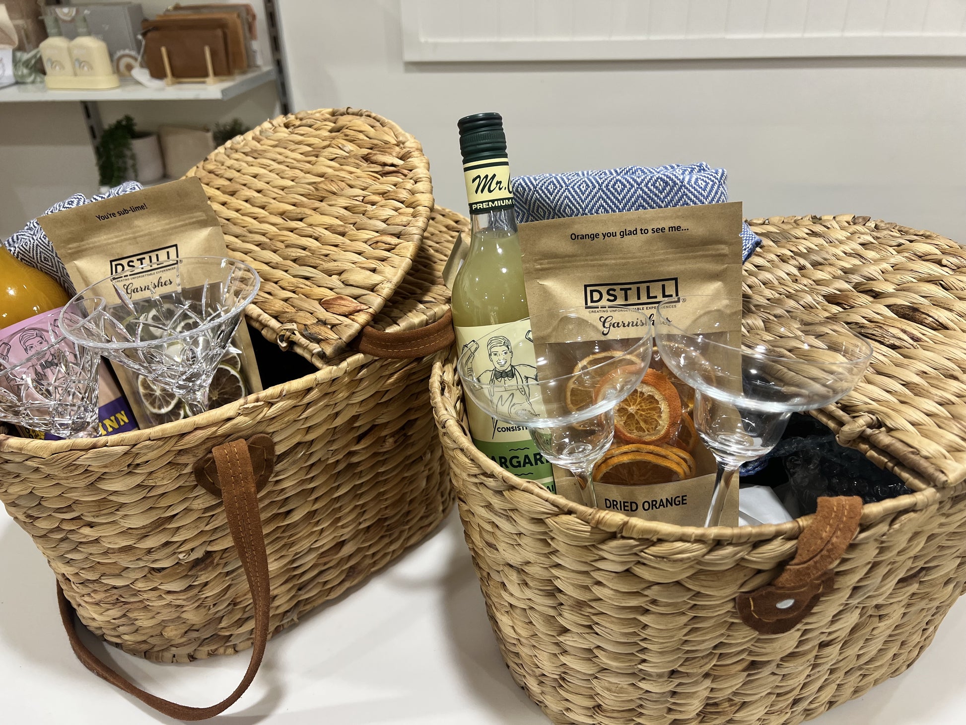 Make the ultimate outdoor date night special with this Cocktail Picnic Basket Gift, complete with a picnic basket, Mr. Consistent cocktail mix, dried fruit, a picnic throw, and DTILL cocktail glasses. Enjoy the sunshine and outdoor adventures with a side of redefined luxury!