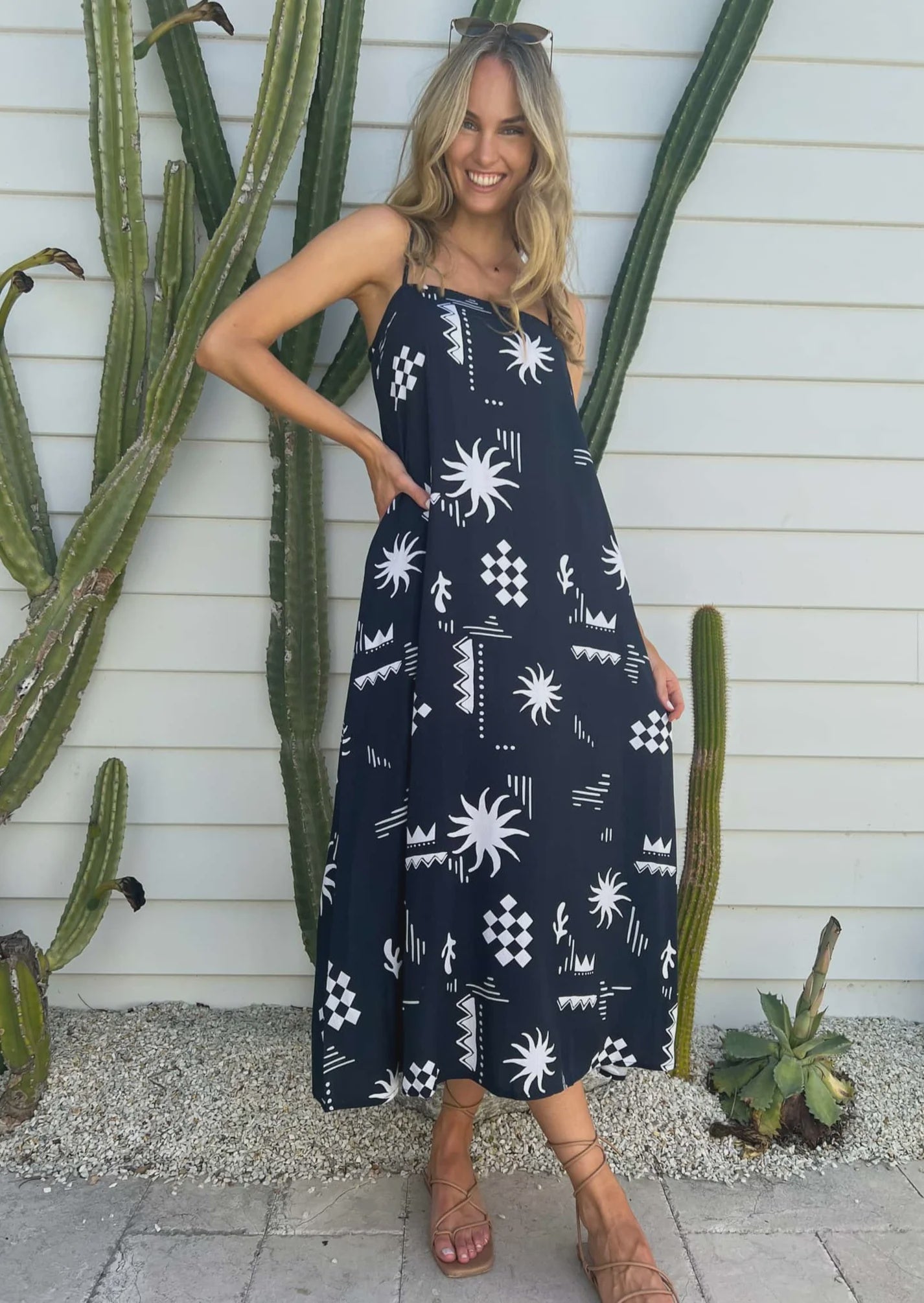 The Celia Maxi Dress boasts a playful square neckline and adjustable spaghetti straps for a perfect fit. It also features convenient pockets and a rouched back for added comfort. Stay effortlessly stylish in this Sol Navy Print design.