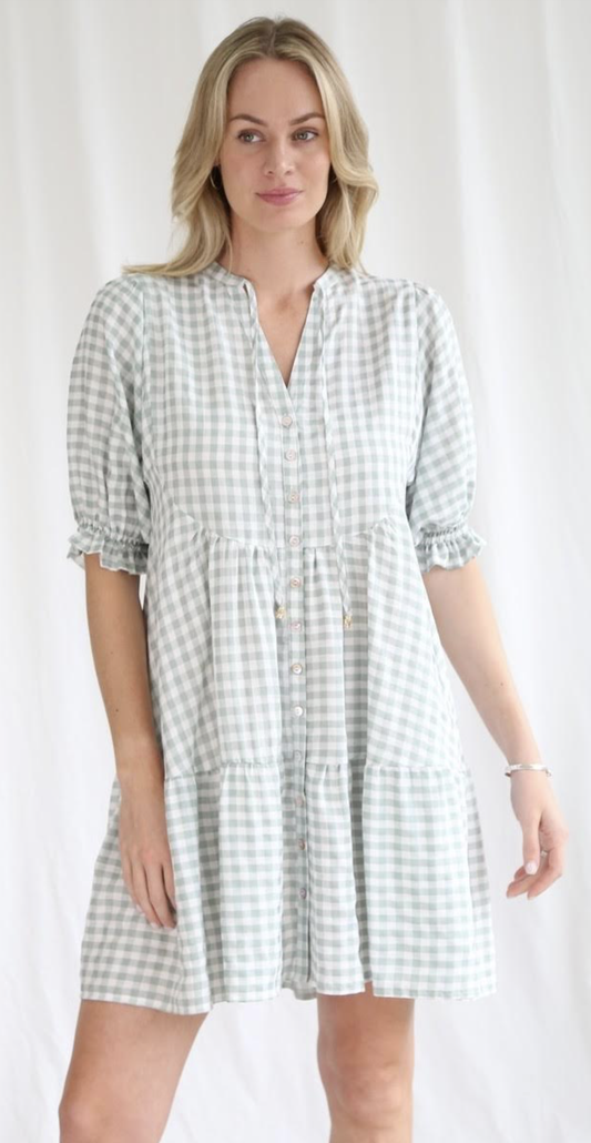 Effortlessly chic and charming, the Ingrid Gingham Mini Dress features a playful v neckline, delightful button details, and a flattering tiered style. With elastic cuff sleeves, this dress offers both comfort and style. Perfect for any occasion, dress it up or down for a versatile and quirky look!