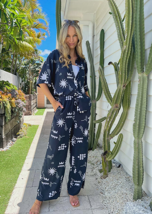 Get ready to rock in the Tanah Set, featuring an oversized top and elasticated drawstring waist for a comfortable fit. With functional buttons and pockets, this navy print set is perfect for any occasion. One size fits all. No need to stress about sizing! (We got you, girl!)\