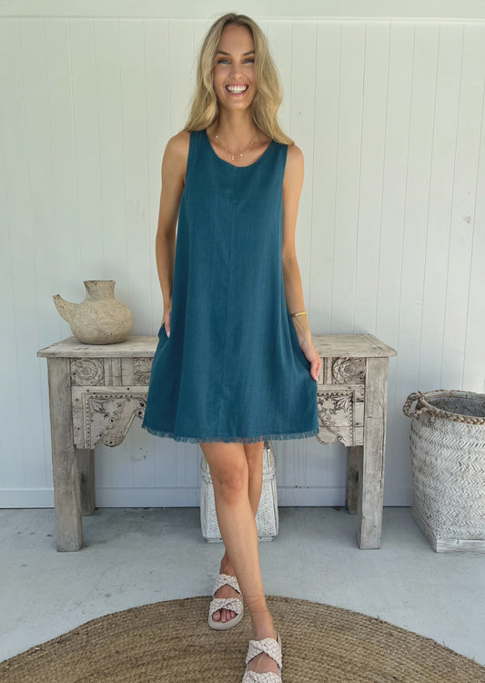 Get ready to stand out in the Freya Dress - Teal! With a frayed hem and shift fit, this dress is both stylish and comfortable. Plus, it even has pockets and is lined for added convenience. Perfect for any occasion, this dress is a must-have in your wardrobe!